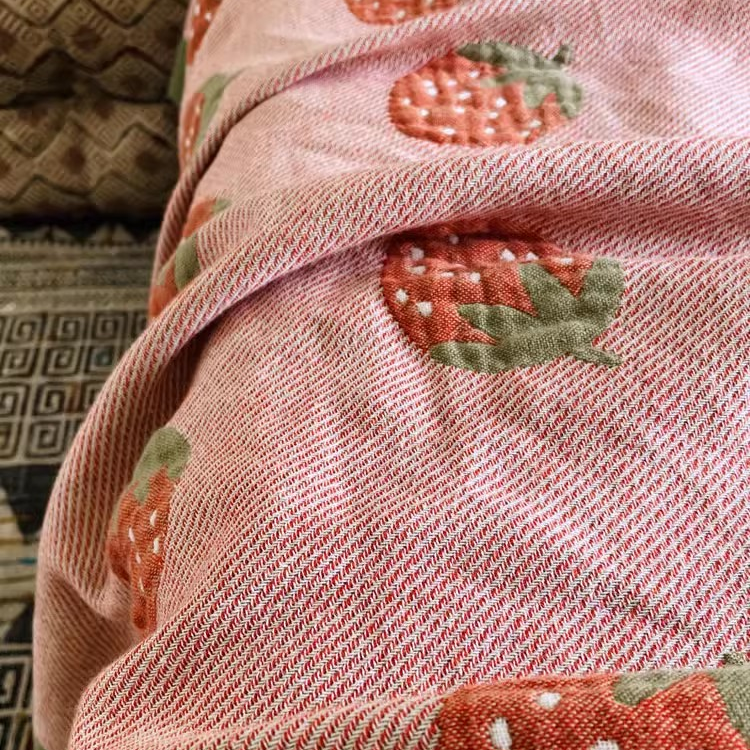 Close-up of Playful Pals Cotton Gauze Quilted Blanket Strawberry showing woven cotton gauze texture and strawberry print