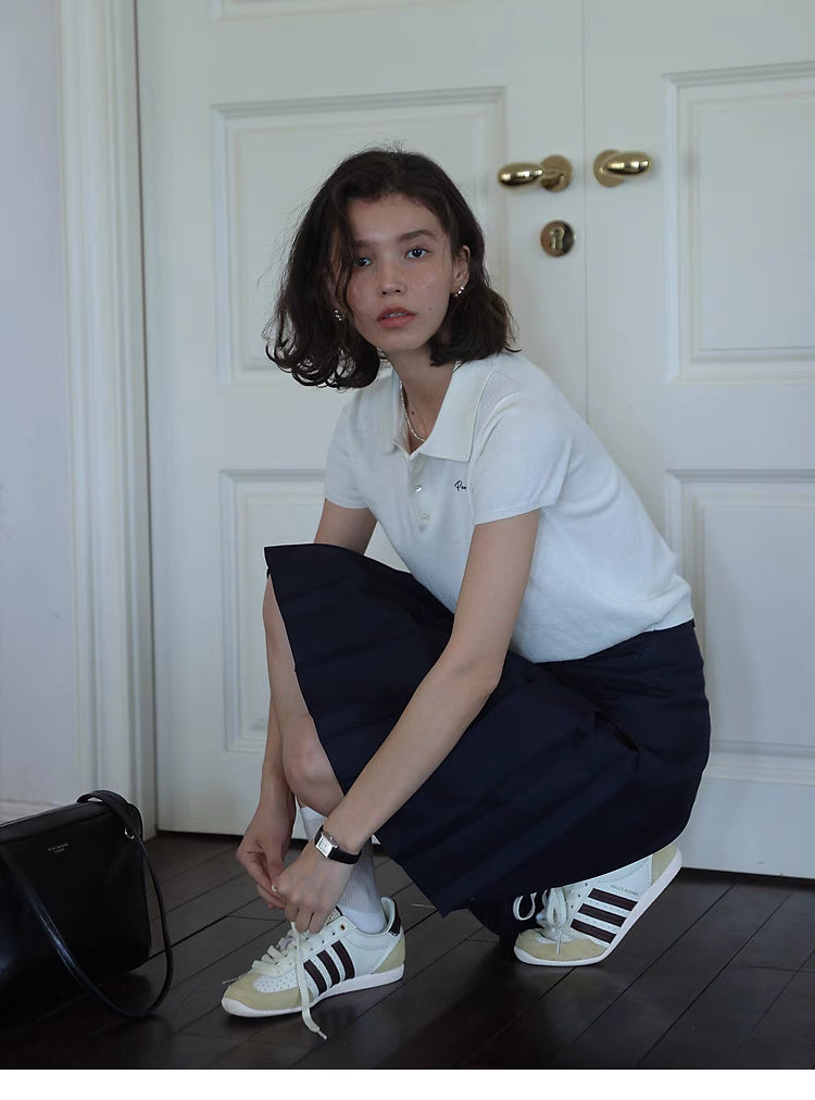 Pleated Chic Skirt navy blue lifestyle sitting pose showing soft fabric drape and elegant pleated movement