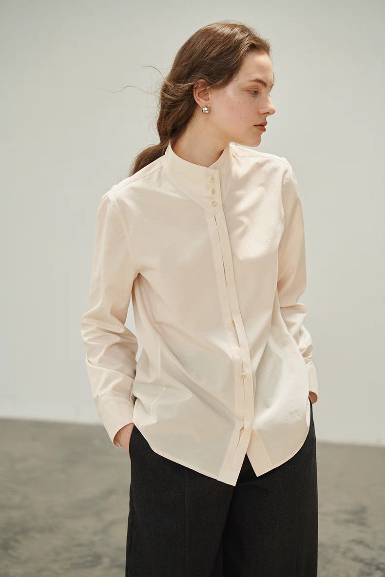 Model wearing Pleated Placket Stand-Collar Shirt in Off-White shown in side profile highlighting clean silhouette, stand collar, and soft cotton-blend texture