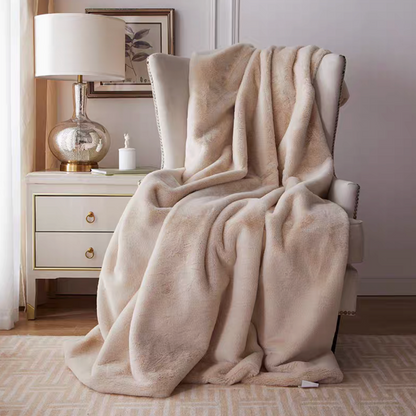 Beige plush reversible faux fur throw blanket draped over armchair in cozy living room setting
