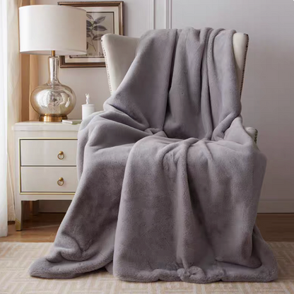 Light gray plush faux fur throw blanket draped over chair in modern elegant home decor