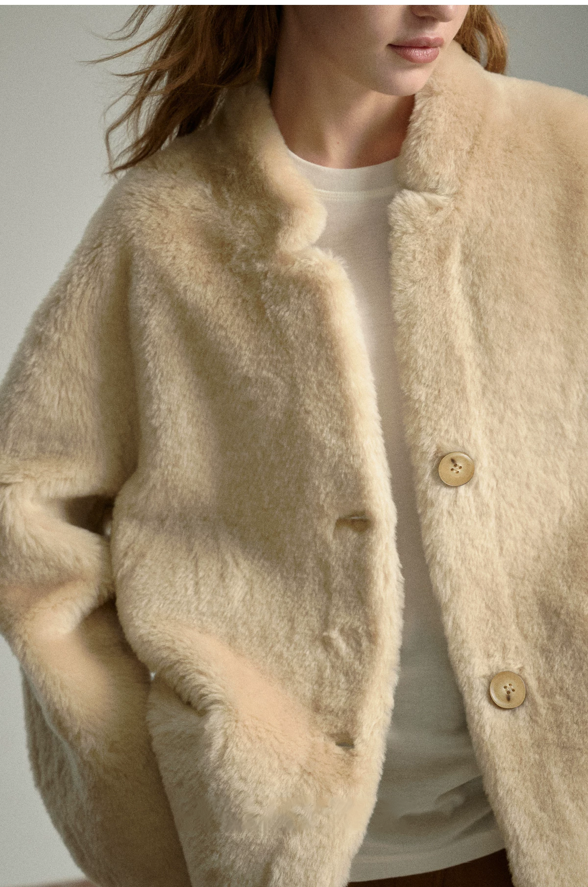 Close-up of oat merino shearling jacket with petite rounded collar and light buttons