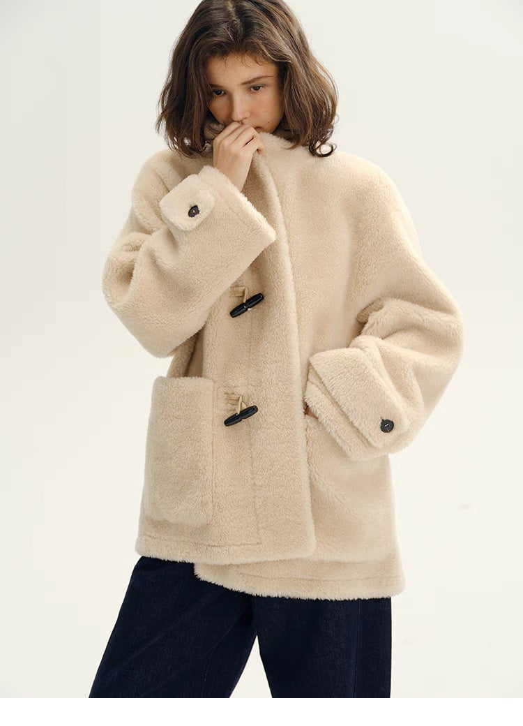 Model wearing Plush Toggle Coat in warm apricot featuring soft plush texture, stand collar, toggle closure, and relaxed oversized fit