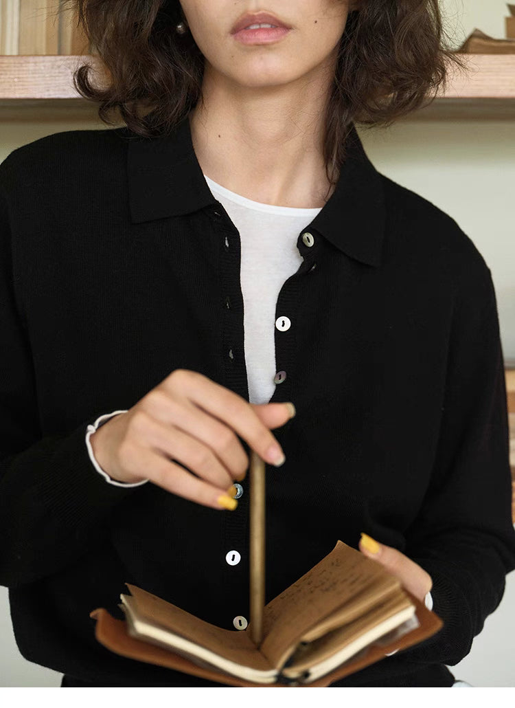 Close-up of black Poised Polo Knit Top showing button closure, polo collar, and knit texture detail