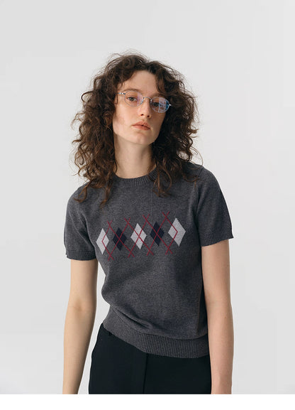 Portrait shot of model wearing charcoal preppy argyle knit tee.