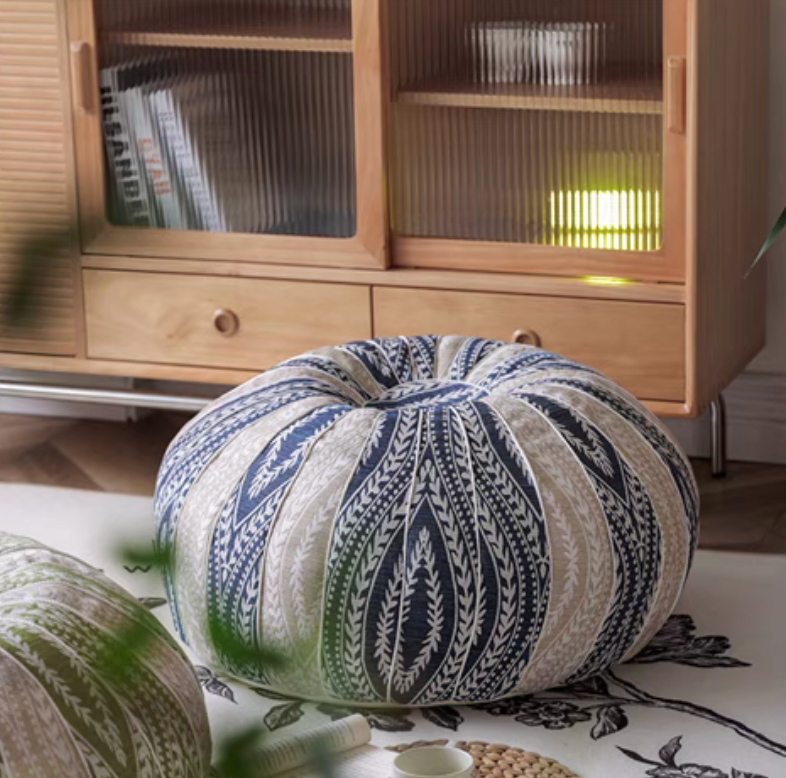 Blue pumpkin round floor cushion placed on the floor beside a wooden cabinet