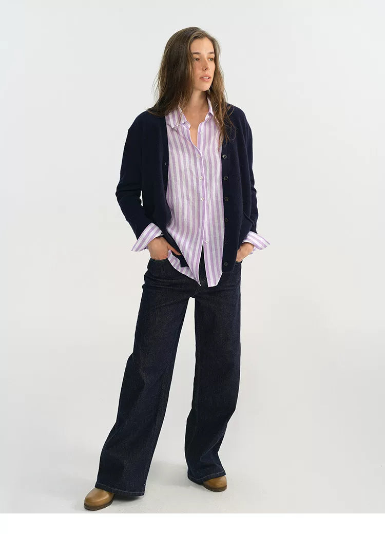 Woman wearing purple stripe linen shirt with navy cardigan and wide-leg jeans