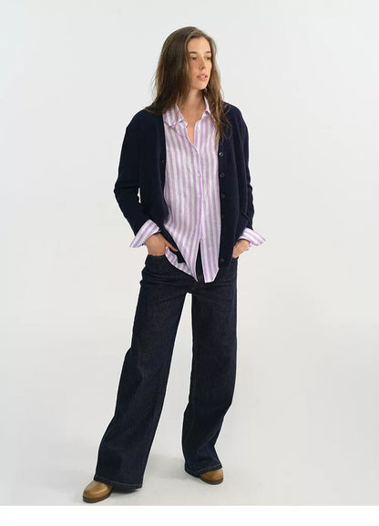 Woman wearing purple stripe linen shirt with navy cardigan and wide-leg jeans
