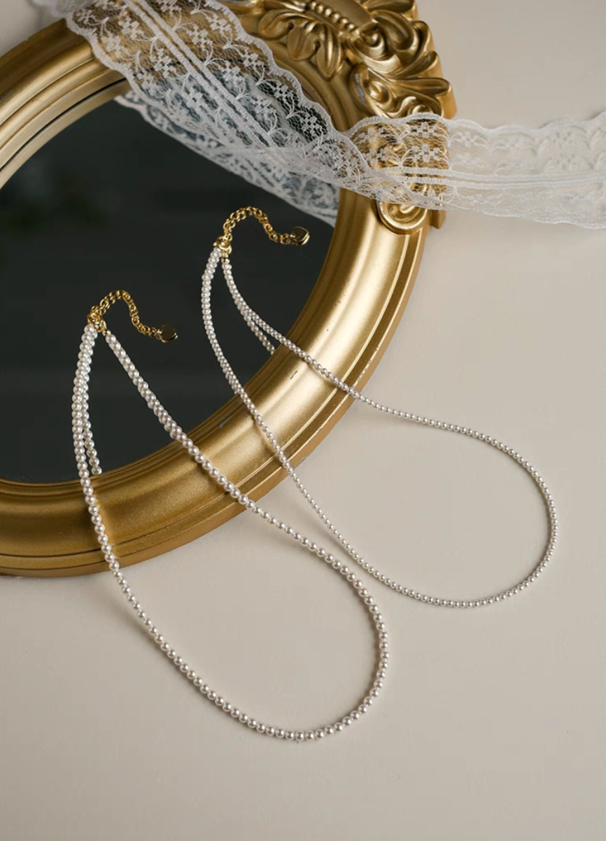 Radiant Round Pearl Necklace in natural color showing two pearl sizes displayed together on ornate mirror