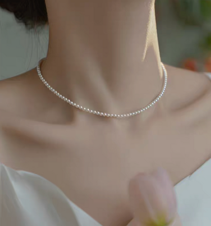 Close-up of model wearing Radiant Round Pearl Necklace in natural color