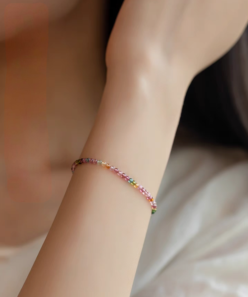 Rainbow tourmaline bracelet worn on wrist single strand close-up elegant everyday styling