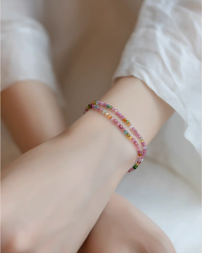Rainbow tourmaline stacking bracelets worn in double layer on wrist showcasing colorful bead variation