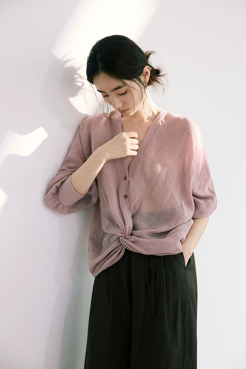 Woman wearing dusty rose ramie-Tencel blouse with black wide-leg trousers