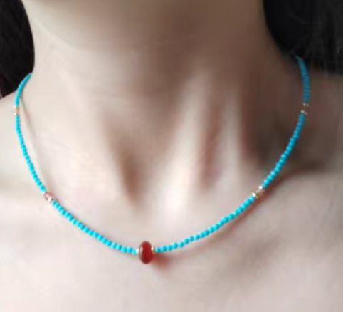 Turquoise seed bead necklace with red agate drop pendant worn on neck showcasing minimalist vintage inspired jewelry style
