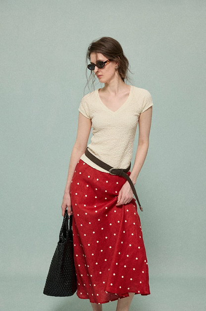 Front view of a red bias-cut linen midi skirt with an elastic high waist