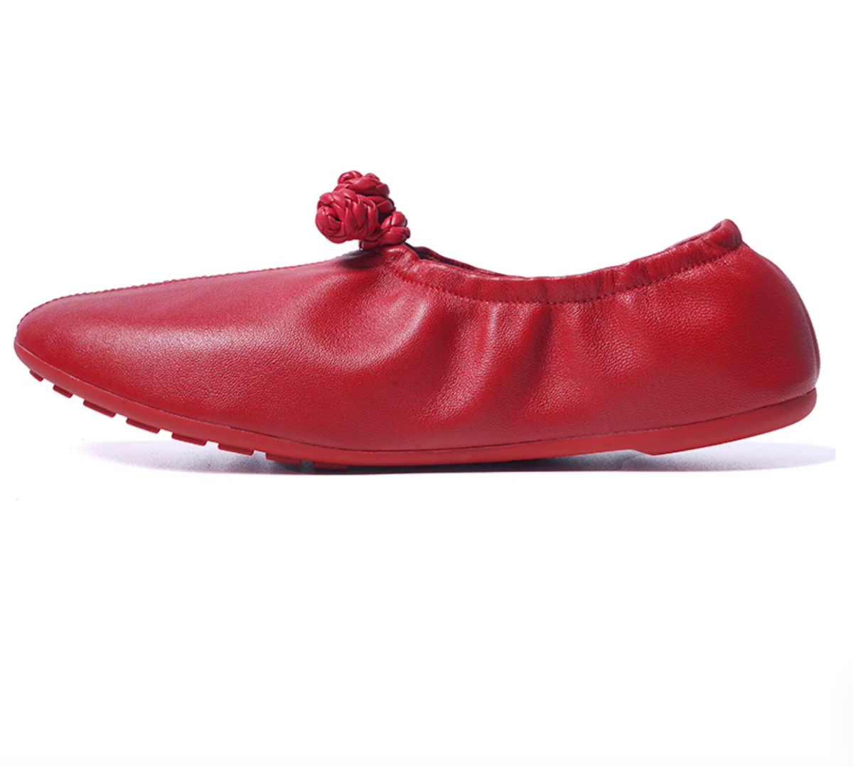 Side profile of a red leather ballet flat with a low flat heel and gathered elastic collar