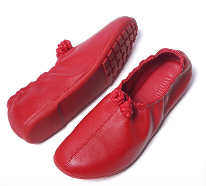 Red ballet flats showing the pebble-lug rubber outsole alongside the braided knot detail
