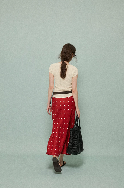 Back view of a red linen polka dot midi skirt falling to the lower calf