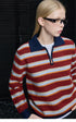 Three-quarter view of Red Stripe polo sweater showing navy collar, half-zip placket and tan zipper pull
