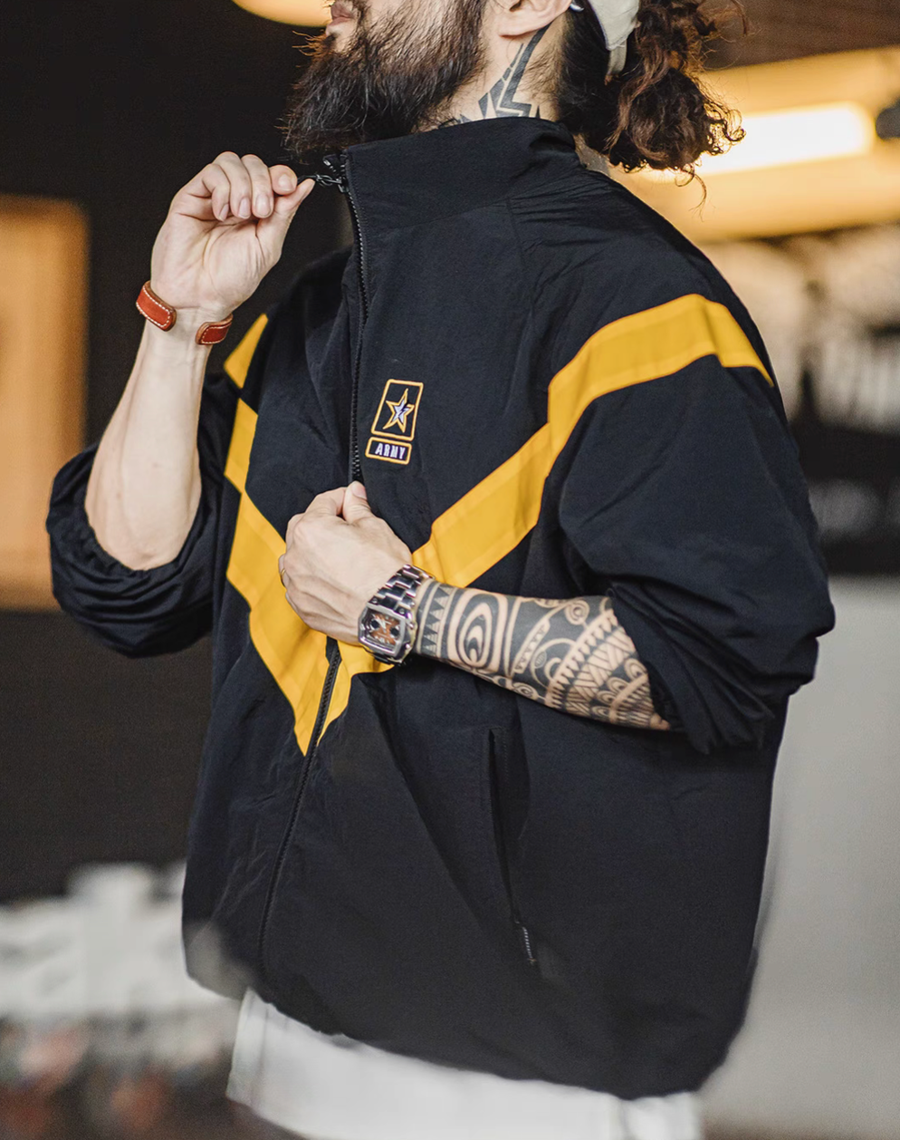 Side view of Black Reflective V-Stripe Tactical Zip Jacket with model adjusting the collar zipper, highlighting the high collar and reflective stripe detail