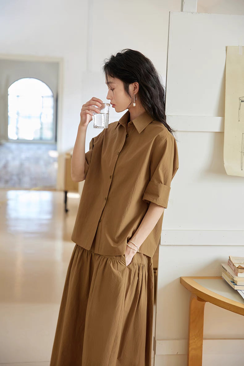 Earth Tone short-sleeve blouse and midi skirt set styled in side view with model holding a glass, highlighting breathable cotton and casual elegance