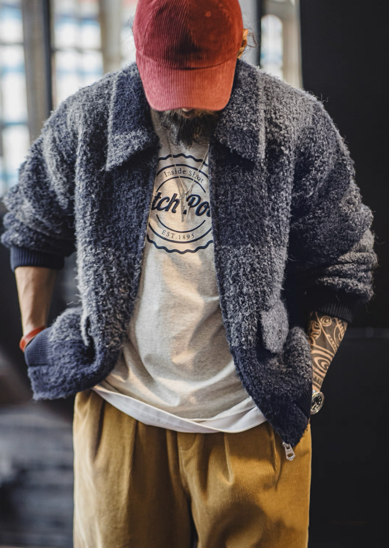 Model in red cap wearing boucle plaid jacket, casual look.