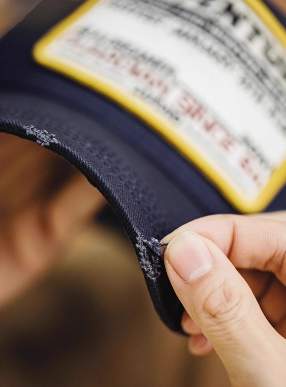 Close-up of Retro Explorer Cap dark blue brim showing distressed edge detail durable cotton twill fabric and premium stitching