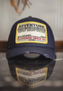 Retro Explorer Cap in dark blue front view with reflective surface showing bold embroidered adventure patch stiff curved brim and structured crown design