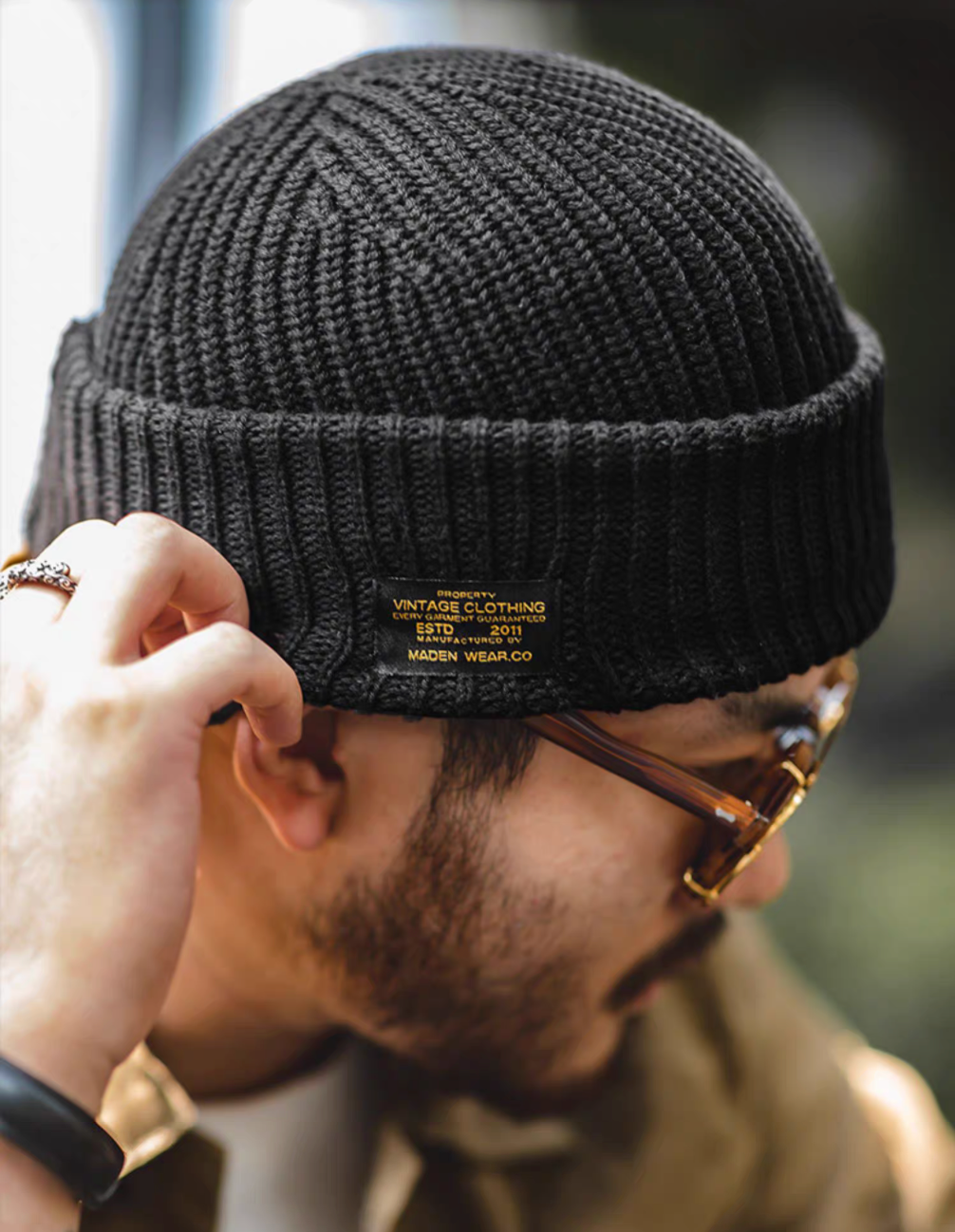 Black Retro Knit Beanie side close up showing ribbed knit texture and vintage style label detail