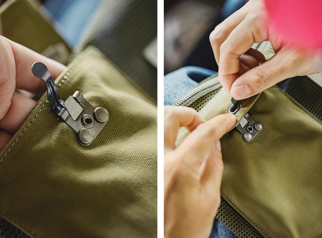 Close-up of metal hook lock and zipper on front pocket of tactical sling bag