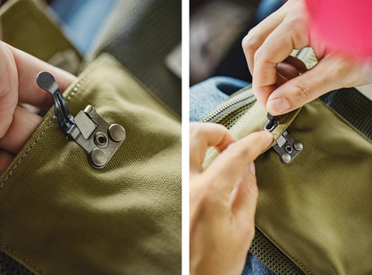 Close-up of metal hook lock and zipper on front pocket of tactical sling bag