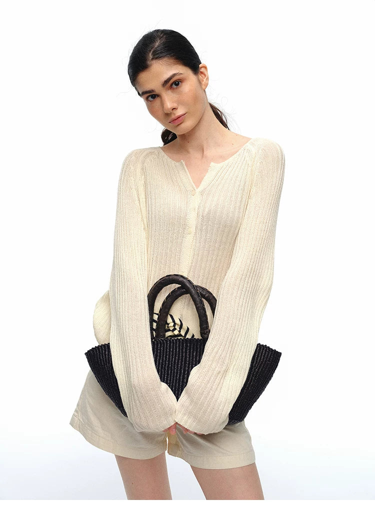 Close-up of ivory ribbed V-neck raglan cardigan with bag
