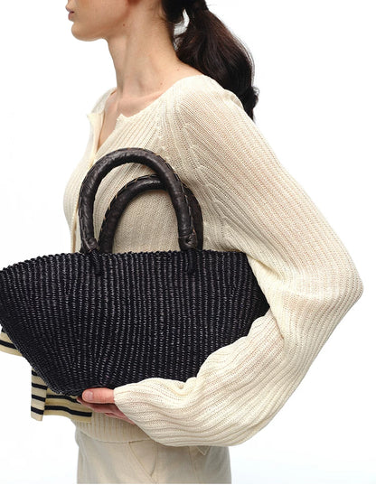 Close-up of ivory ribbed cardigan sleeve and bag detail