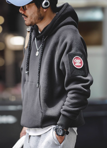 Side profile of RidgeLine Fleece Hoodie in black worn with headphones showing braided drawstrings and modern urban styling