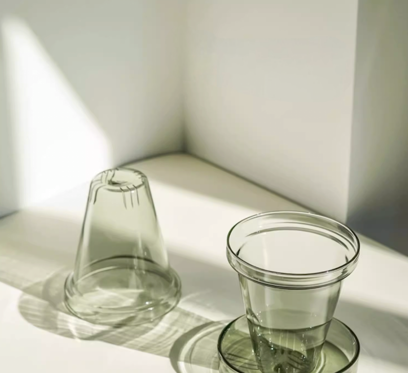 Light Green glass tea filter and lid components of ceramic mug shown separately, highlighting transparent infuser design and structure
