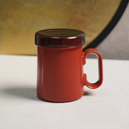 Red Ringmug ceramic mug with lid attached, front view highlighting ring handle and minimalist cylindrical shape