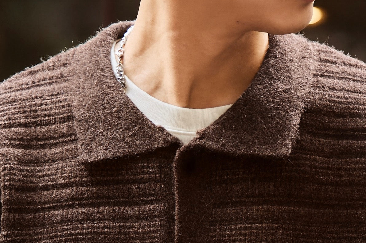 Close-up of soft fuzzy knit shirt collar on brown ripple textured cardigan