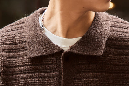 Close-up of soft fuzzy knit shirt collar on brown ripple textured cardigan