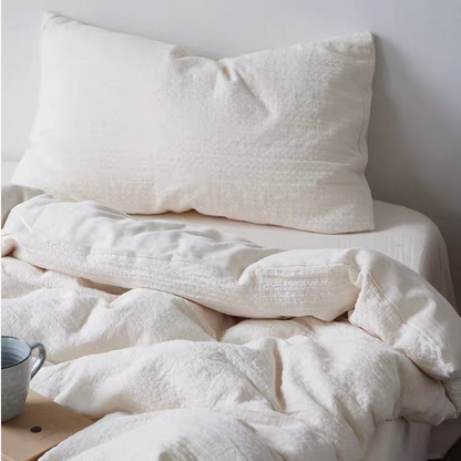 Rock Point cotton comforter, sheet and shams set in cream styled on bed creating warm minimalist bedroom look