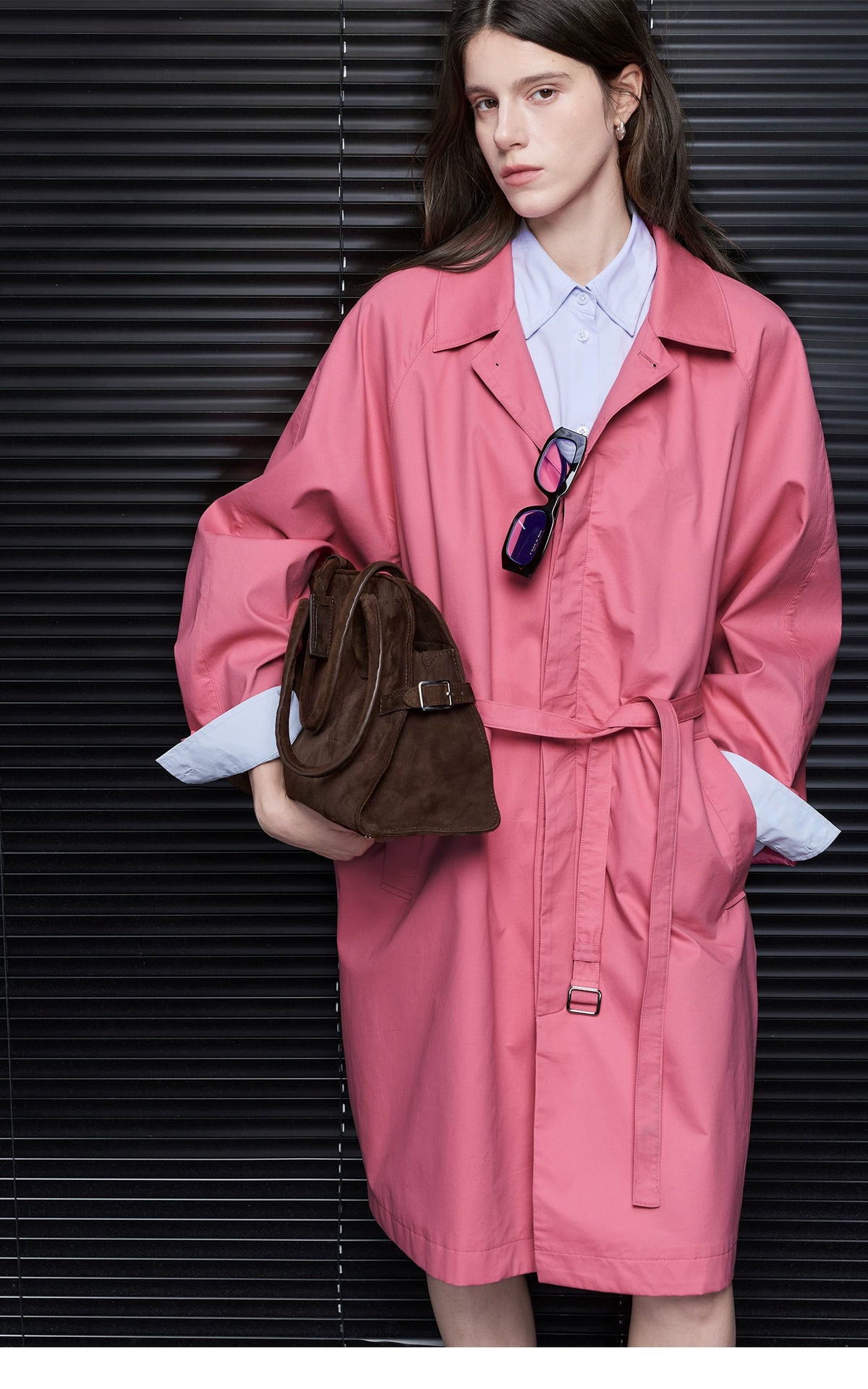Rose Pink oversized cotton trench coat belted at the waist, showing the fly front and buckled lower tab