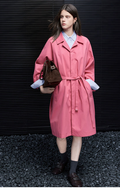 Full-length front view of a Rose Pink belted trench coat with wide raglan sleeves and in-seam pockets