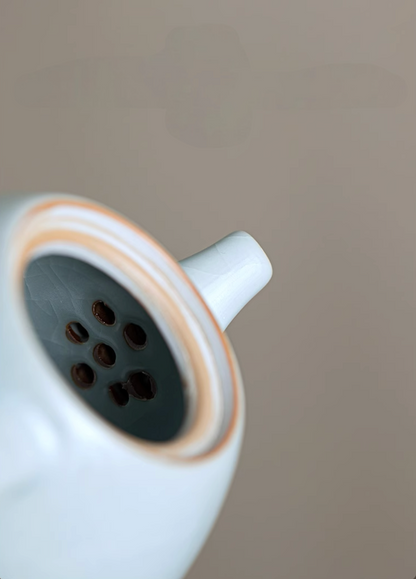 Close-up of Ru Kiln Celadon Mini Teapot in light blue showing built-in spout filter holes and inner ceramic detail