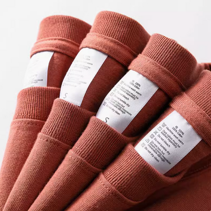 Rustic T-Shirt red stacked shirts with visible care labels showing cotton fabric and stitching detail