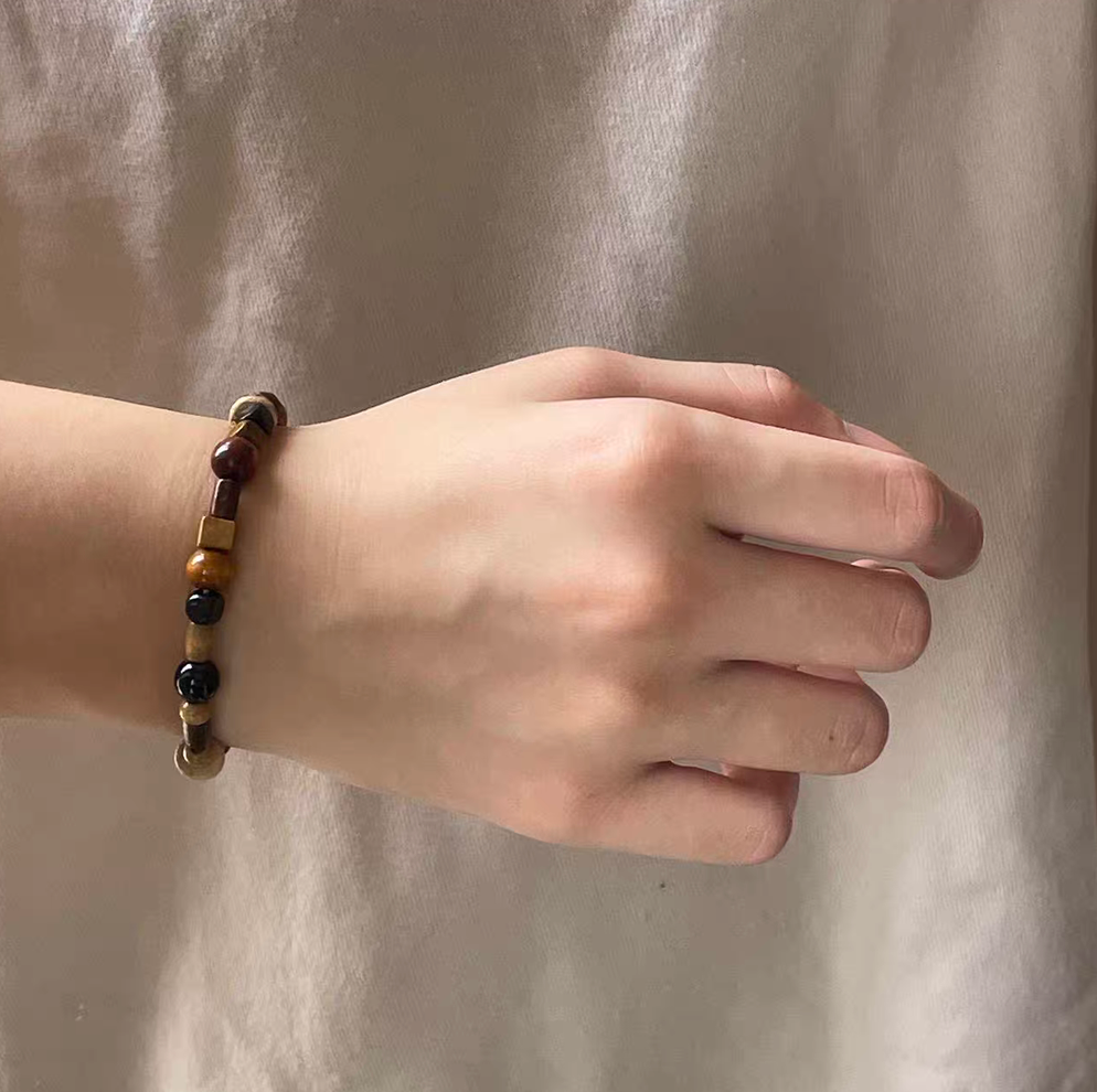 rustic wooden elements bracelet worn on wrist showing multicolor wooden beads with natural textures
