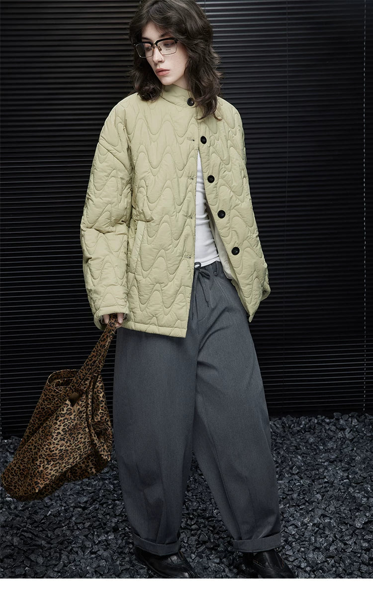 Front view of a Sage Green hip-length quilted down jacket worn partly unbuttoned