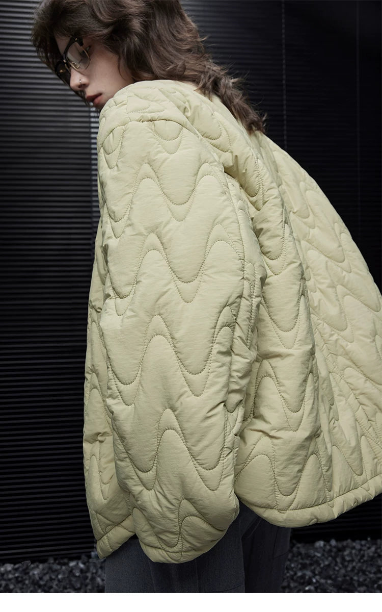 Back-side view of a Sage Green down jacket showing the curved sleeve and wave quilting