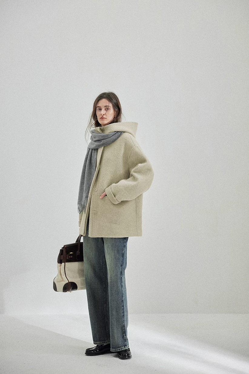 Side view of a Sage boxy hooded wool coat with dropped shoulders and rolled sleeves