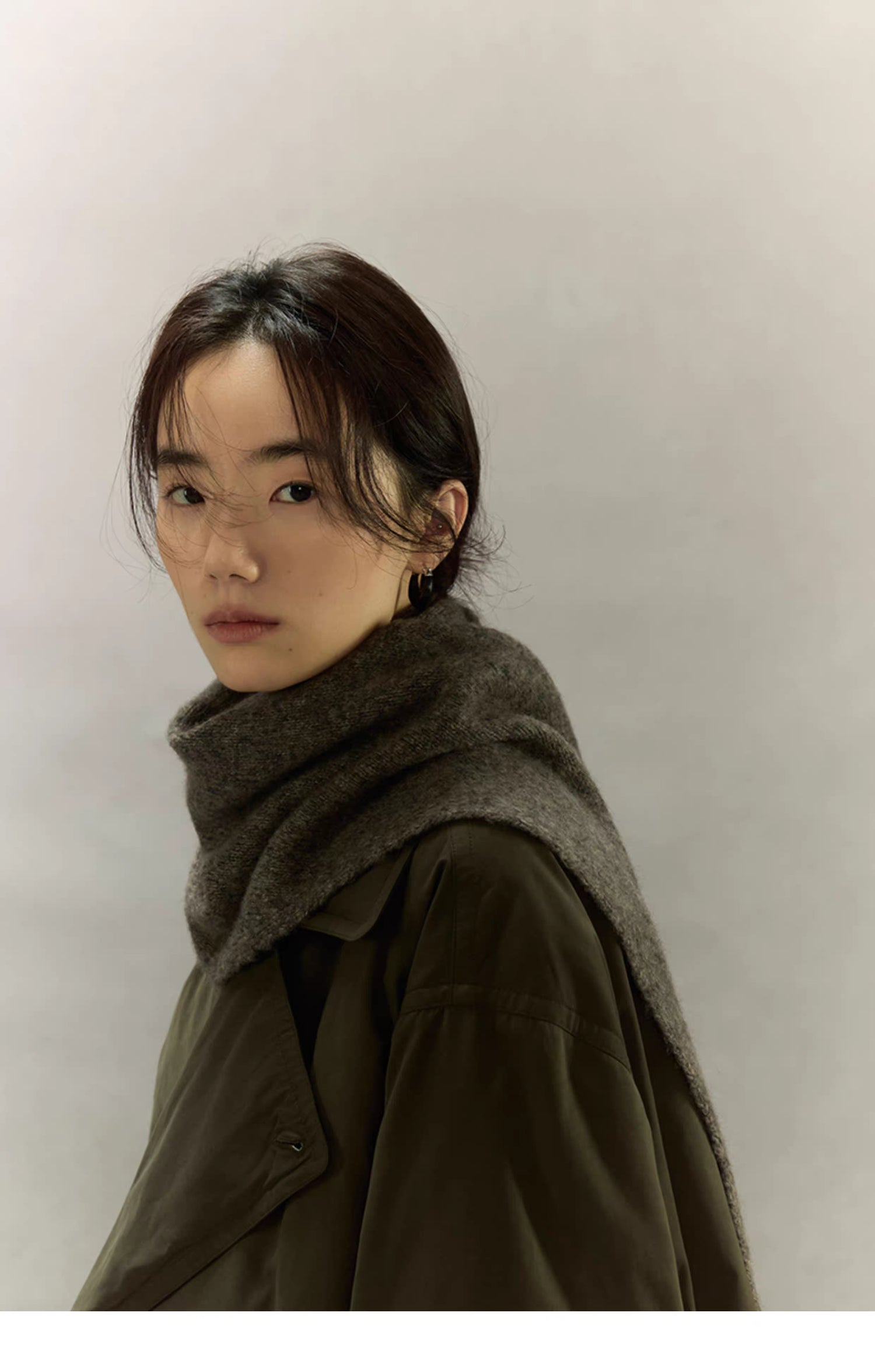 woman styling charcoal brown cashmere wool scarf with olive trench coat