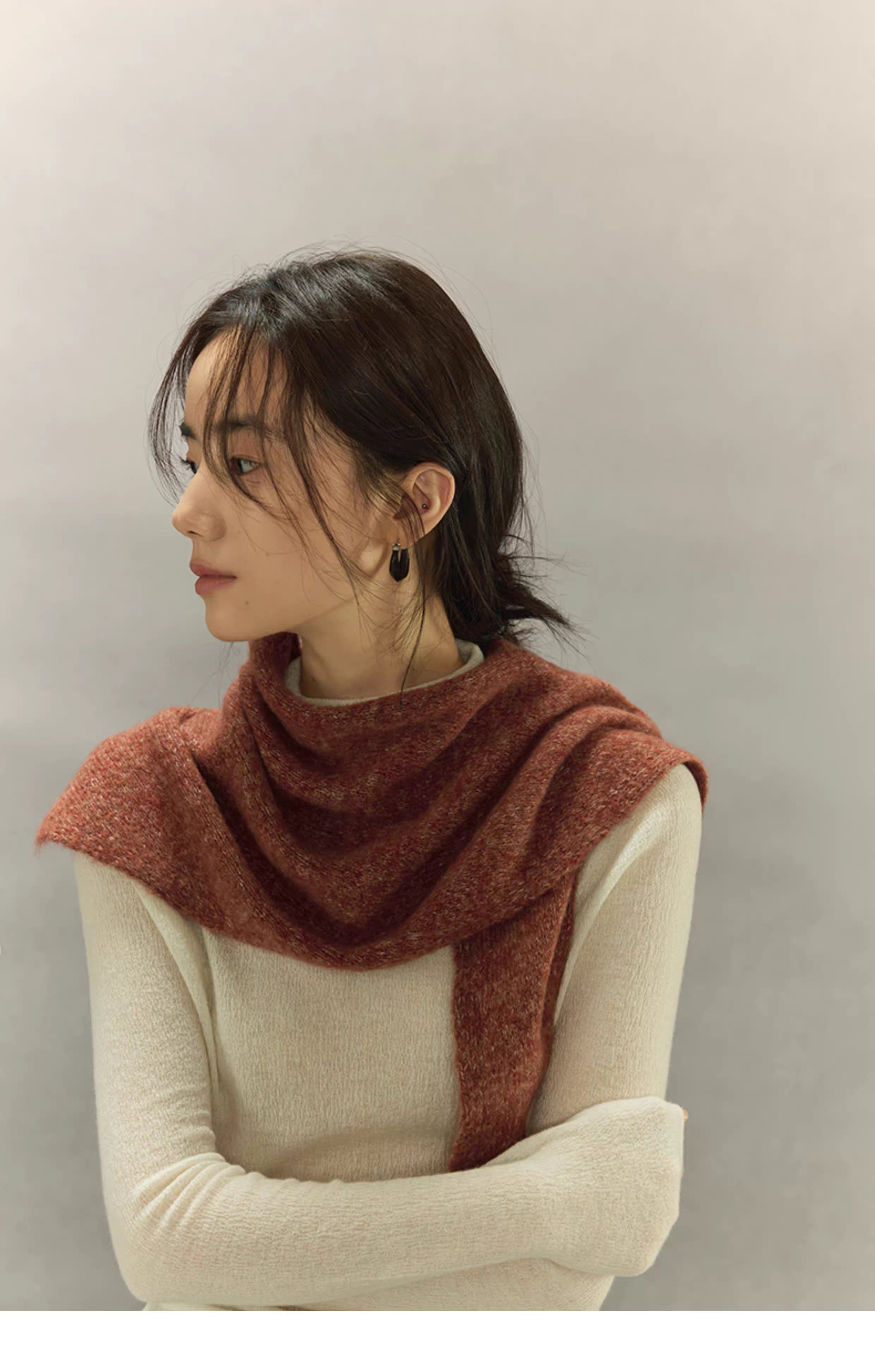 woman wearing rust brown knit scarf styled around shoulders in side view