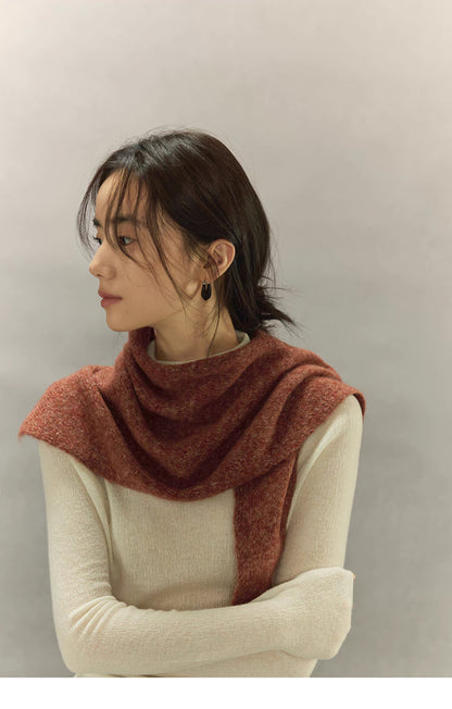 woman wearing rust brown knit scarf styled around shoulders in side view